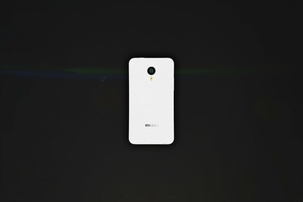 Weißes Smartphone auf schwarzem Schreibtisch