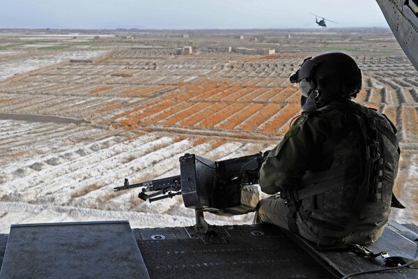 Ein Soldat mit einem Maschinengewehr, der in den Horizont schaut