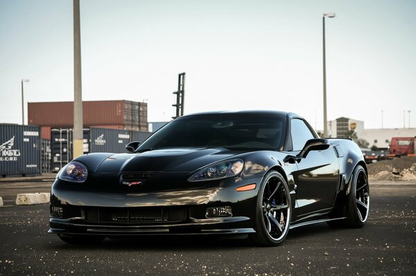 Schwarzer Chevrolet zr1 im Hintergrund einer urbanen Landschaft
