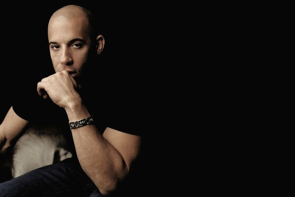 Vin Diesel mit einem Armband am Arm im Dunkeln