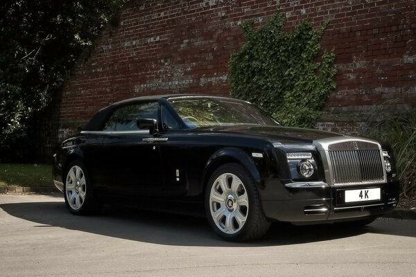 Schwarzer rolls-royce auf dem Hintergrund einer alten Burgunderwand