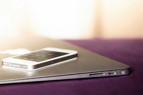 iPhone und MacBook liegen ruhig auf dem Tisch