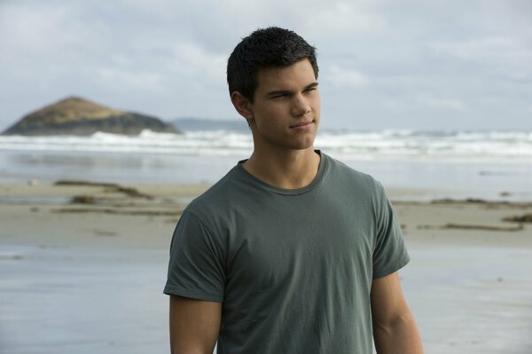 Jacob Black trägt ein T-Shirt an der Küste