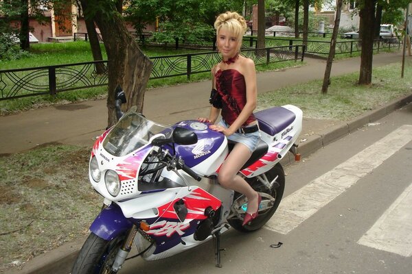 Frau in einem Minikleid mit einem Motorrad unterwegs