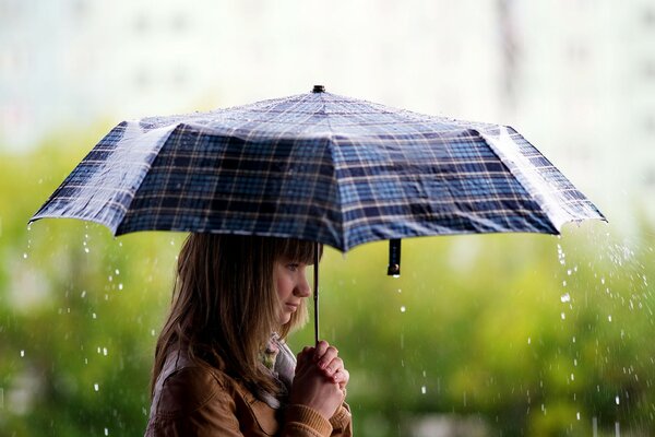 Brünette Mädchen mit Regenschirm im Regen