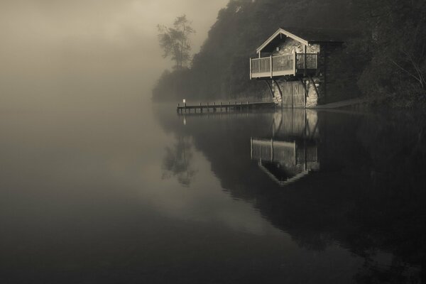 See im Nebel mit einsamem Haus