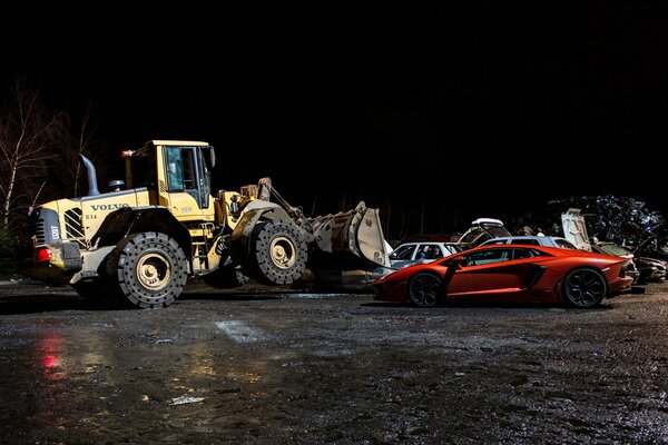 Volvo Bulldozer in der Nacht mit orangefarbenem Lamborghini