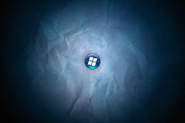 Das Windows-Logo auf einer blauen Schaltfläche auf einem zerknitterten Papierhintergrund