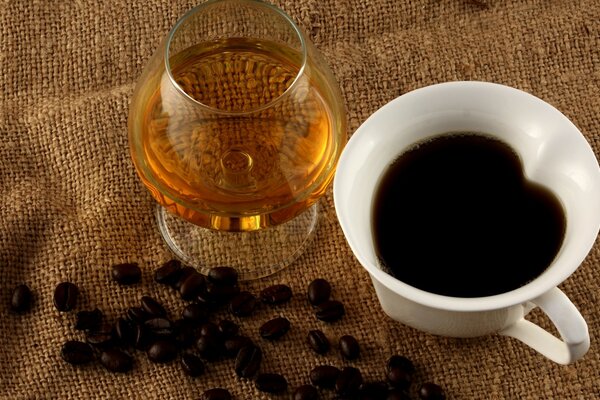 Ein Glas Cognac und Kaffee auf einem Sackleinen