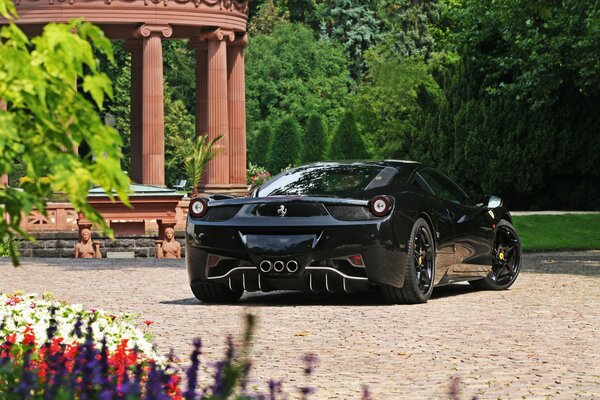 Ein schwarzes Ferrari-Auto steht im Garten