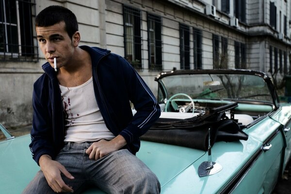 Schauspieler Mario Casas sitzt und raucht im Auto