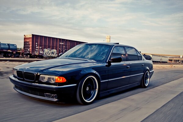 Blauer bmw 740i auf dem Weg zum Bahnhof