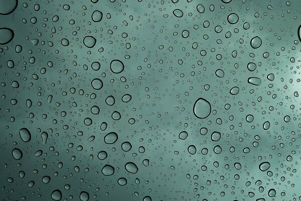 Wassertropfen auf grünem Glas