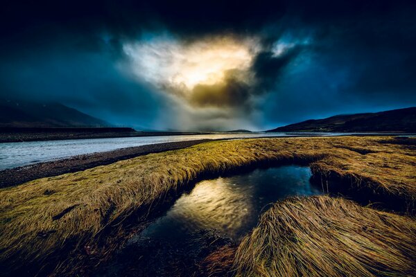 Nächtlicher Fluss und dichte Wolken