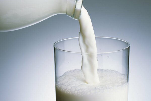 Die Milch wird in ein transparentes Glas gegossen