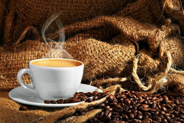 Dampfender Kaffee in Tassen und Kaffeebohnen