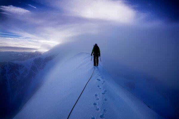 Ein Bergsteiger geht durch schneebedeckte Berge