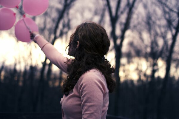 Mädchen hält rosa Ballons in der Rückseite ihres sind unscharfer Hintergrund