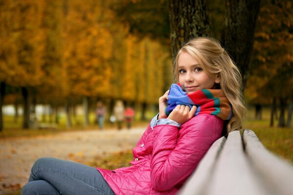 Mädchen auf einer Bank mit Herbststimmung