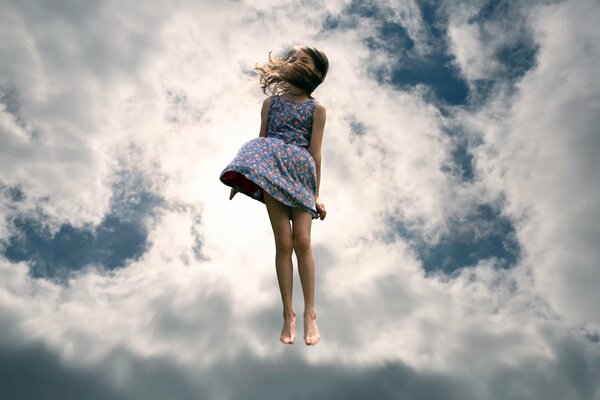 Sprung in die Wolken. Mädchen im Himmel