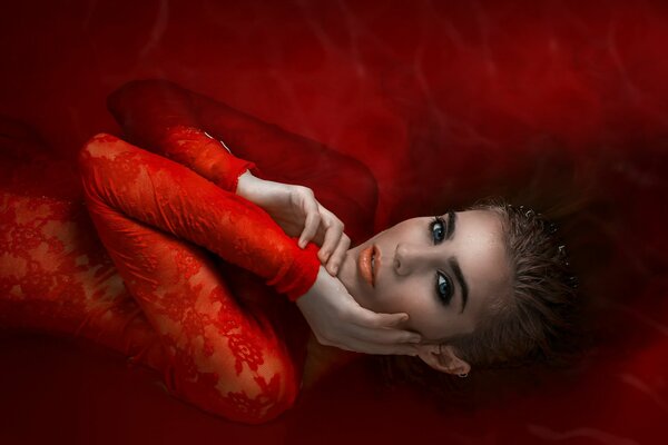 Mädchen in rot im roten Wasser