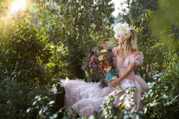 Mädchen sitzt in der Natur mit Blumen