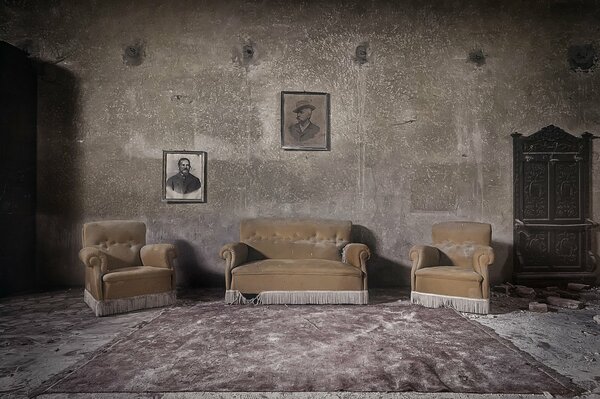 Altes Zimmer mit Sofa und Porträts an der Wand