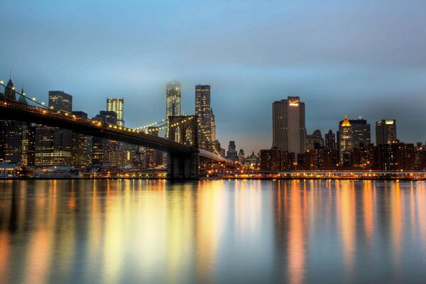 Abendlicher Blick auf die Wolkenkratzer von New York und Brooklyn Bridge