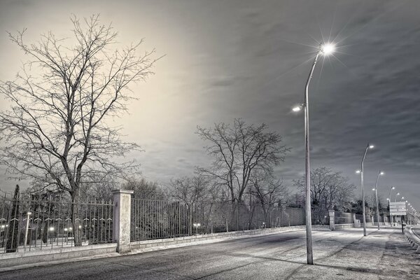 Straße mit brennenden Laternen in der Dole der Straße