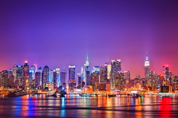 Die Lichter der Nacht in Manhattan spiegeln sich im Hudson River wider