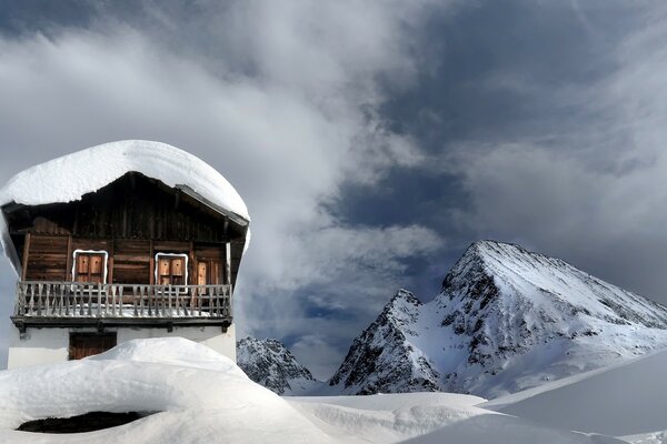 Ein Haus in den Bergen. Schnee. die Berge