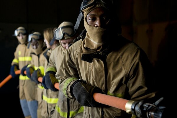 Fünf Feuerwehrleute halten den Schlauch fest