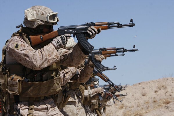 Soldaten in Ausrüstung schießen aus Kalaschnikow