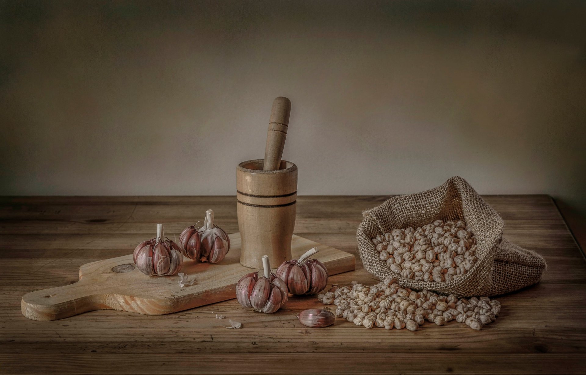 knoblauch kichererbsen erbsen brett stößel mörser stillleben