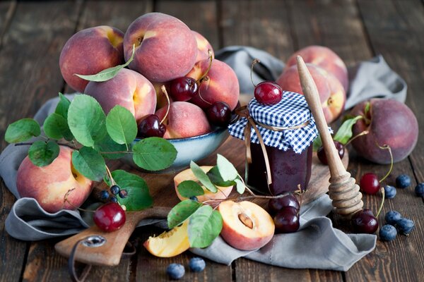 Stillleben aus Pfirsichen und Beeren. Obst auf dem Tisch