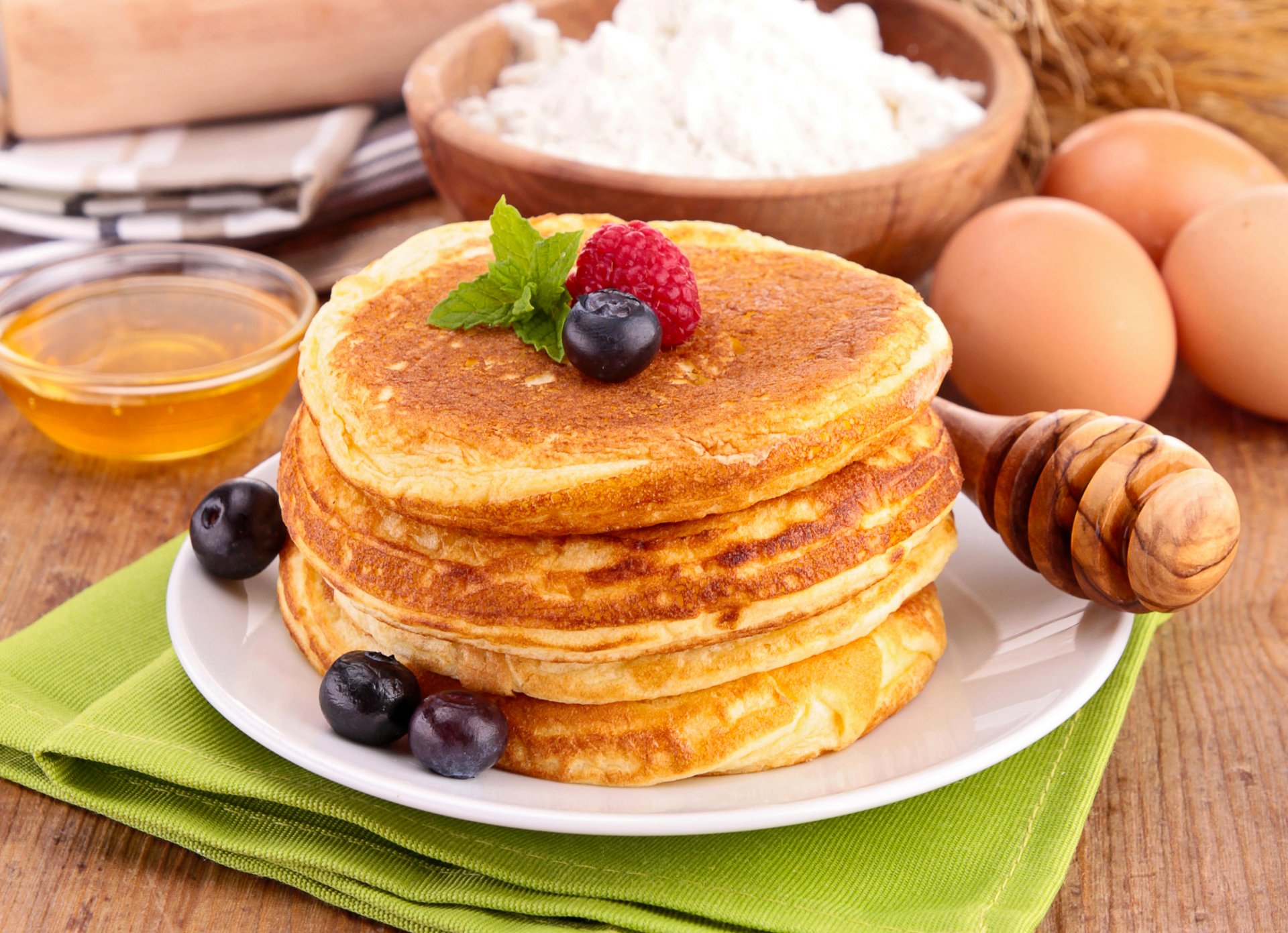 pfannkuchen pfannkuchen pfannkuchen honig himbeeren blaubeeren beeren geschirr löffel mehl essen