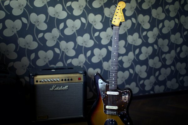 Eine Gitarre mit Verstärker steht an der Wand