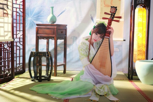 Asiatische Mädchen spielt Musik auf einem Instrument