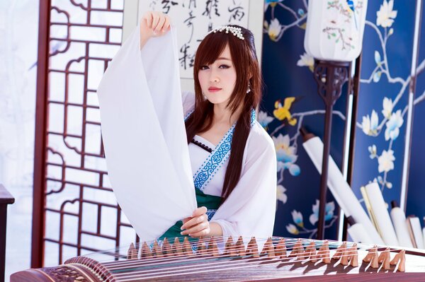 Asiatische Mädchen in weiß mit Musikinstrument