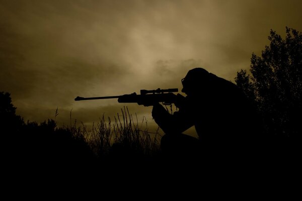 Scharfschütze im dunklen Feld mit Waffen