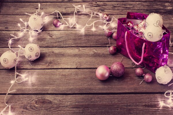 Rosa Weihnachtsgirlande mit leuchtenden Luftballons auf Holzboden