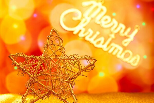 Metallisches Weihnachtssternspielzeug auf Bokeh-Hintergrund und Frohe Weihnachten-Schriftzug