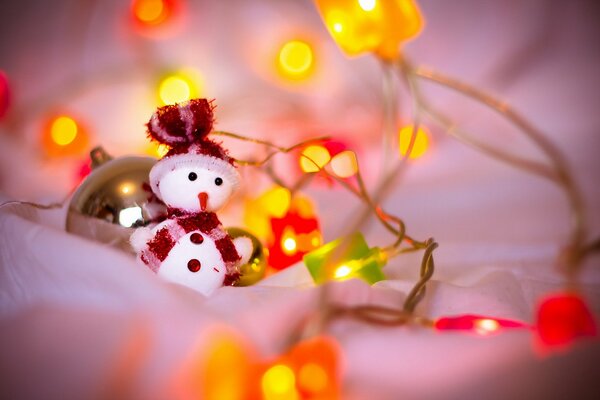Spielzeug-Schneemann in Lichtern zu Weihnachten