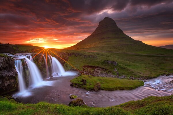 Wasserfall und Vulkan in Island mit Sonnenuntergang