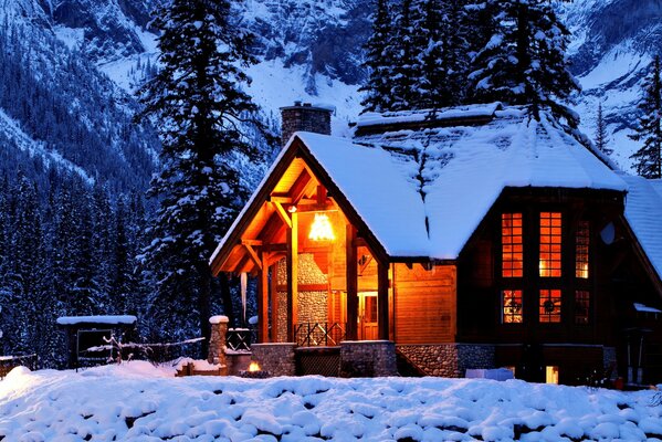 Ein Haus in der winterlichen Natur zwischen Bergen und Bäumen