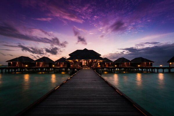 Blick vom Pier auf ein Bungalow-Hotel auf den Malediven